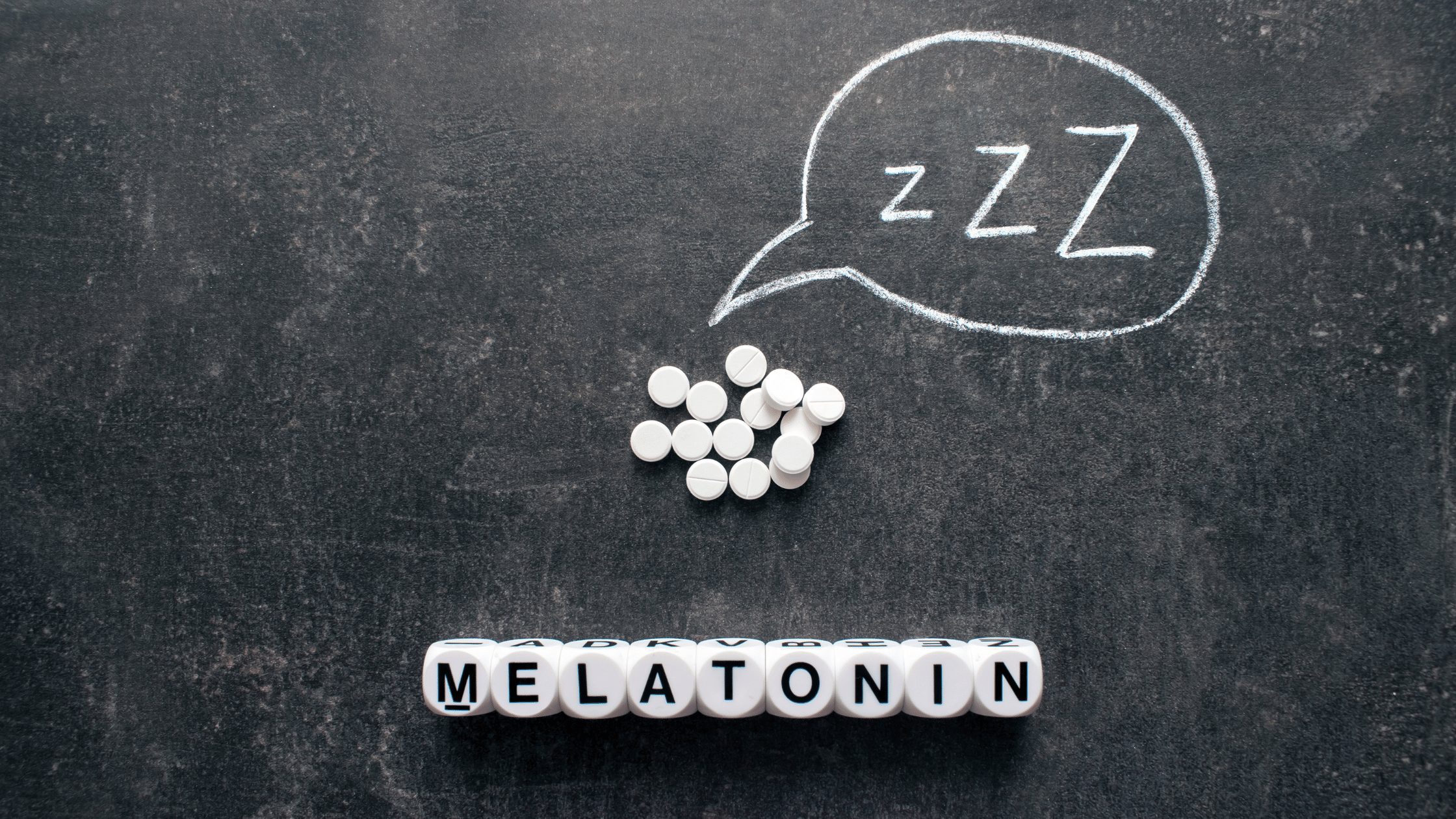 melatonin spelled out with dice on a chalkboard background